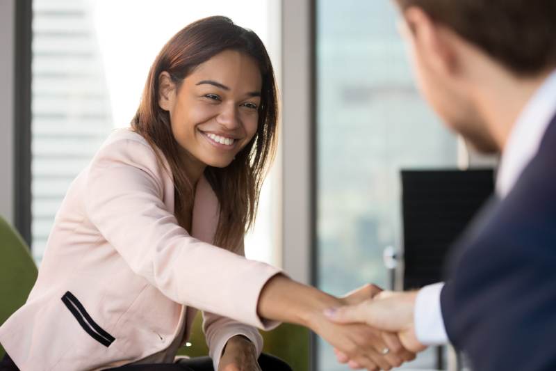 Conflict Management: A Creative Approach to Breaking Impasse - A woman shaking hands across the negotiation table.